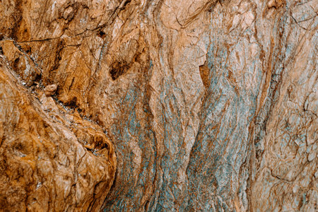 A flat background of a brown with blue tones rock with rocky texture