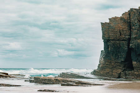A massive cliff near the wild sea in the beach of the cathedrals in Spain with copy spaceの写真素材