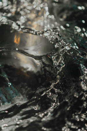 A background of time stopped water on white, black and green tones with copy spaceの写真素材