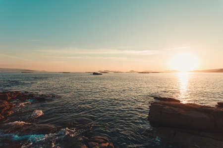 A massive sunset over the islands of Cies in Spain with the ocean in front with copy spaceの写真素材