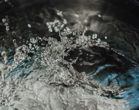 A background of time stopped water on white, black and blue tones with copy spaceの写真素材