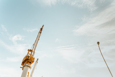 A minimal shot of a yellow industrial crane with a the blue sky as the background and copy spaceの写真素材