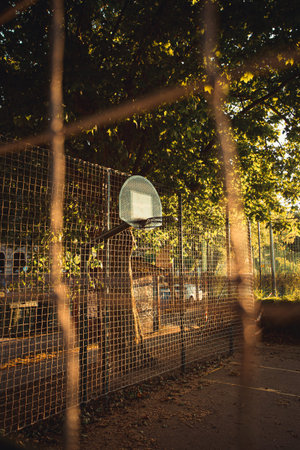 A close up of the basket from the fence in the court during a sunset