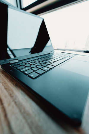 A close up of the keyboard of a laptop over a wooden tableの写真素材