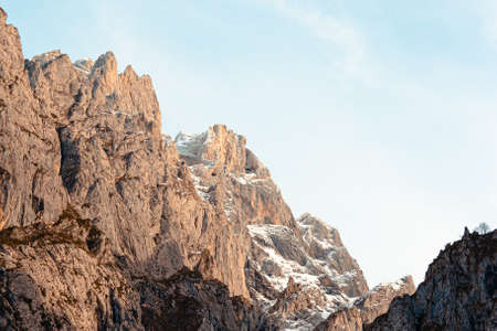 A giant rocky mountain on pink and meat tones with a bright blue sky backgroundの写真素材