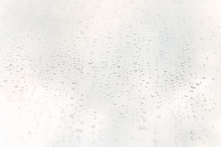 A minimalistic and clean background with water drops over a crystal clear whiteの写真素材