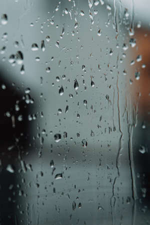 Some rain drops over the crystal of a window during a sad dayの写真素材