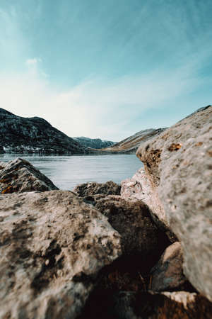 A frozen lake view from the rocks of the border with a bright blue skyの写真素材