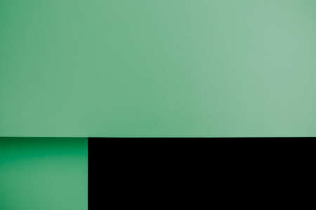 A pastel green and black flat lay background with sharp layers and shadows with copy spaceの写真素材