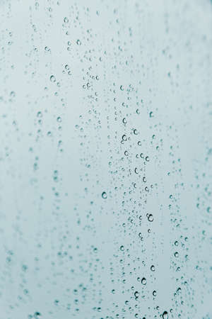 A vertical background of some rain drops over a crystal surfaceの写真素材