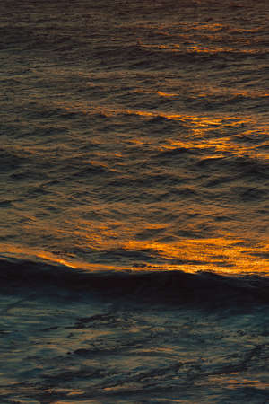 A massive and peaceful wave in a colorful ocean with copy space during a sunsetの写真素材
