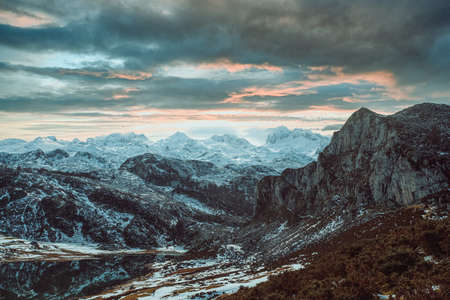 Some massive mountains with a storm over it with snowy peaksの写真素材