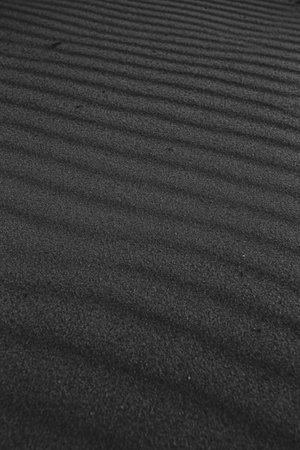 A black and white super texture and repetitive background of the sand of the beach with a great patternの写真素材