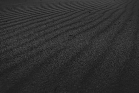 A black and white super texture and repetitive background of the sand of the beach with a great patternの写真素材