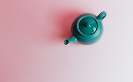 A minimalistic blue teapot over a pastel pink background with copy spaceの写真素材