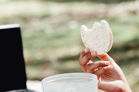 A hand grabbing a healthy food in the parkの写真素材