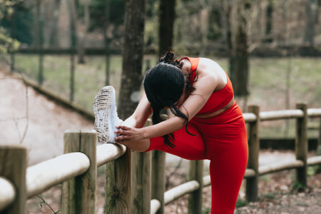 Young woman in fitness clothes stretching his body at the park with copy spaceの写真素材