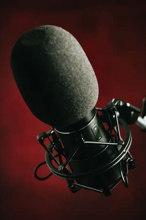 A close up of a streaming microphone over a red background with copy spaceの写真素材