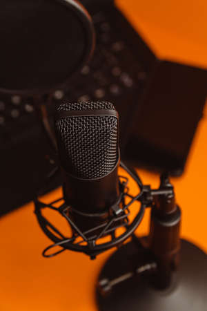Close up mock up of a streaming microphone with a laptop over an orange background with copy space, minimal concept, technology streamingの写真素材