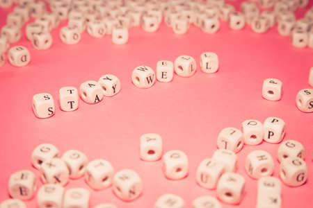 White dices over a pink pastel background with stay well message, wellness and life conceptsの写真素材