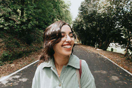 Young Moroccan woman smiling to camera in autumnal and desaturated colors with copy space and modern clothesの写真素材