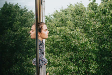 Woman worried while showing off the window in the city during a spring day, mental health conceptの写真素材
