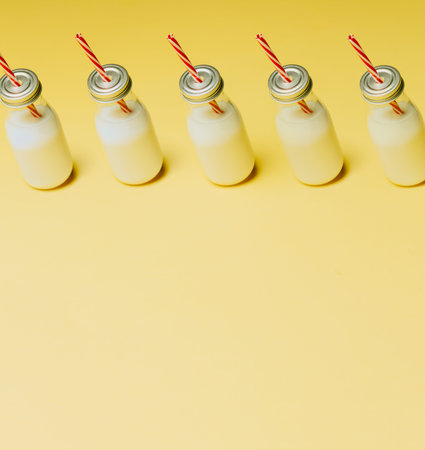 Super minimalist mockup of a milkshake pattern over a pastel yellow background with copy spaceの写真素材