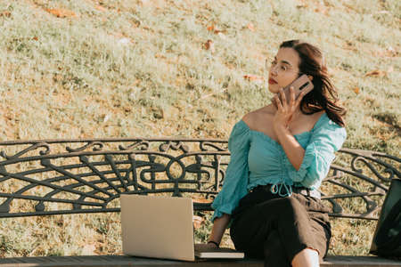 Young woman making some call on his phone during a super bright day with copy space work outside concept making call businessの写真素材