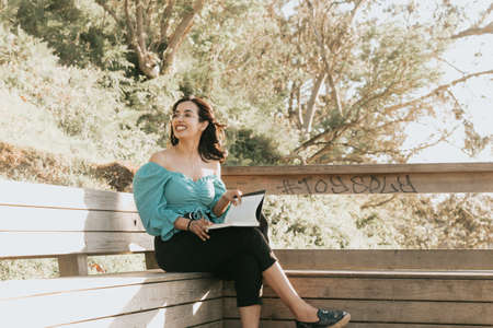 Young woman reading at the beach during a super sunset while using a mask relax and inspirational concepts with copy space lifestyle colorfulの写真素材