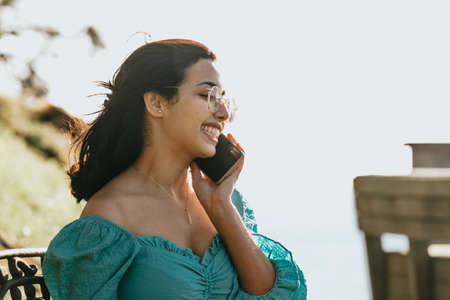 Young woman making some call on his phone during a super bright day with copy space work outside concept making call businessの写真素材