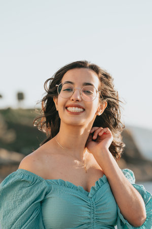 Young woman with glasses smiling to camera during a super sunny day with copy space lifestyle concept happy dayの写真素材