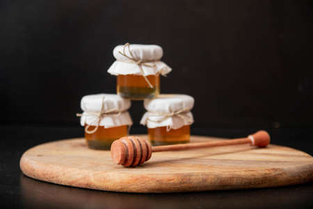 three glass jar with honey isolated on black backgroundの写真素材