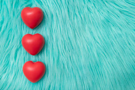 The red Heart shapes on abstract turquoise furの写真素材