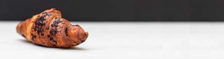 From above of delicious fresh crusty croissant and pieces of dark chocolate composed on a dark background. banner,の写真素材