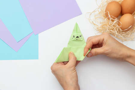DIY Children's Easter craft bunny with an egg. Easter paper step by step instructions. Step 18. Happy bunny holds egg. Children's Art Project, needlework, crafts for children, springtimeの写真素材