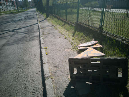 The storm wind has blown the traffic sign down. The sign was there to warn drivers about bad condition of the roadの写真素材