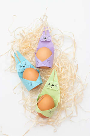 Happy bunny holds egg. DIY Children's Easter craft bunny with an egg. postcard for easter holiday.