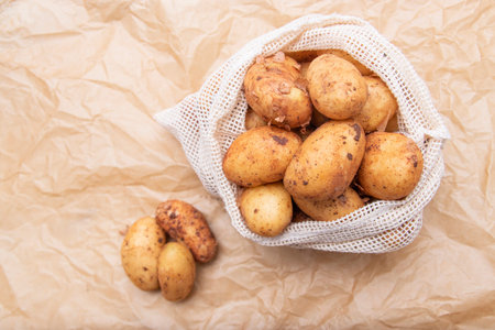 Raw fresh organic potatoes. Full bag of potatoes. Burlap sack with potatoes. Space for text,の写真素材