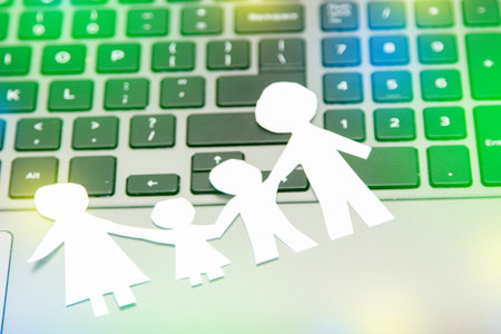 family made of paper, a symbol of a happy strong family, on the background of a computer keyboard....
