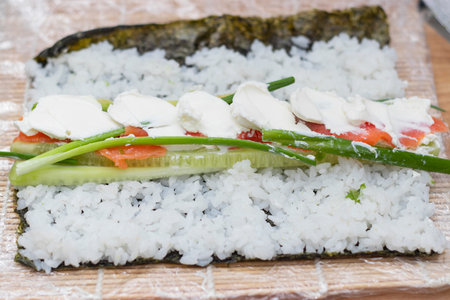 Preparing, rolling sushi and rolls from rice, red fish, avocado and philadelphia cheese.の写真素材