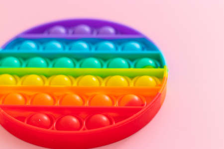 Antistress pop it toy. New popular silicone colorful antistress popit toy for child on pink background. View from above. Copy space.の写真素材