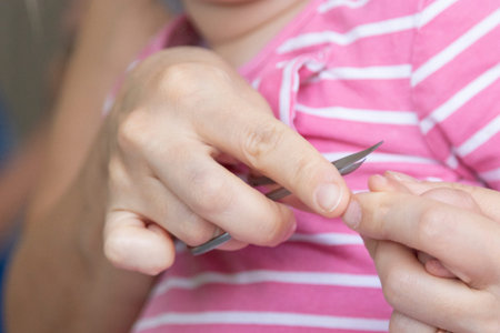Mother is cutting her child's fingernails. Trim baby's nails. the concept of motherhood and care....