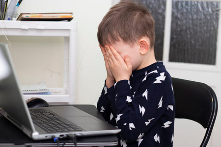Funny shocked kid with a laptop. Protect child on homeschooling