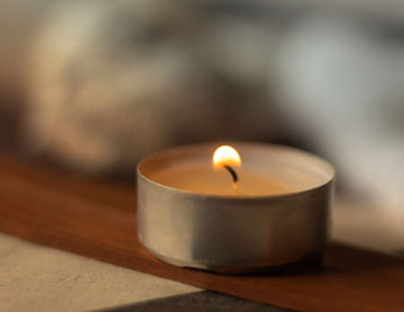 incense lit by a candle and releasing smoke in a spa for healing therapyの写真素材