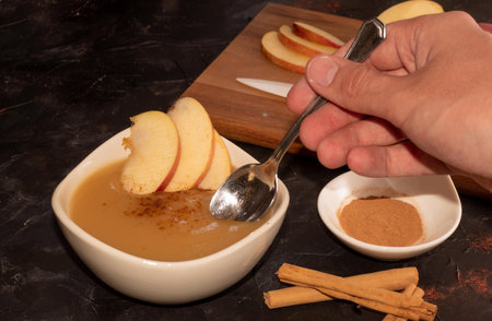tasting the cinnamon apple puree with sliced red apples and cinnamon sticks