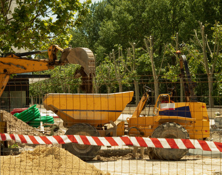 urban work with a yellow digger throwing the soil into a container