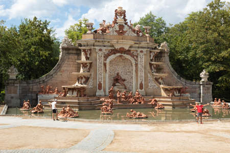 Young people watching and taking pictures at the famous fountain in La Granja de San Ildefonso Palace 18th century Royal Palace in the province of Segovia in Spain on a summer dayの写真素材