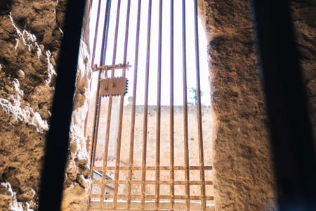 antique metal door with lock, closing the access and with the back lightの写真素材