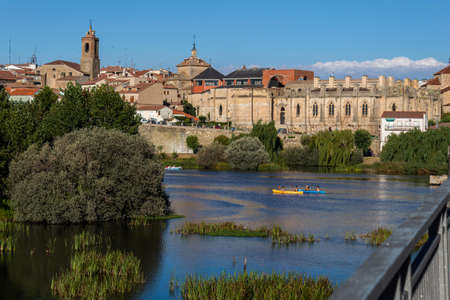 AVILA, SPAIN - August 2020, 14: selective focus of the view from the Alba de Tormes Bridge in Spain along its river navigable by canoes on a sunny dayのeditorial素材