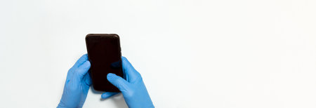selective focus of a doctor or nurse holding the mobile phone with blue latex gloves to perform...